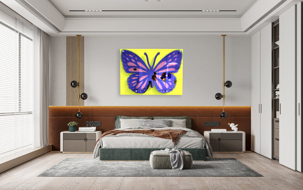 A modern bedroom showcases uniQstiQs Large Butterfly Art—an acrylic, 3D pop art wall sculpture with a purple butterfly on yellow background—creating a bold focal point above the bed.