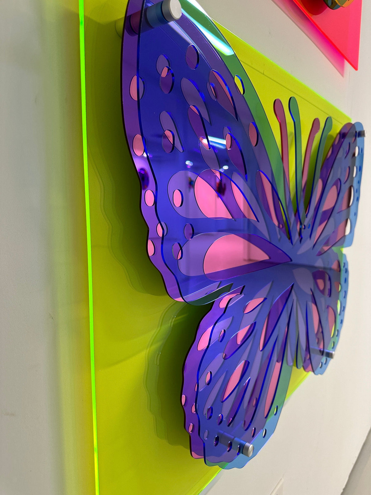 The uniQstiQ Large Butterfly Art features a layered acrylic butterfly in purple and pink on a neon yellow-green base, creating bold 3D Pop Art wall decor perfect for lovers of abstract, contemporary designs.