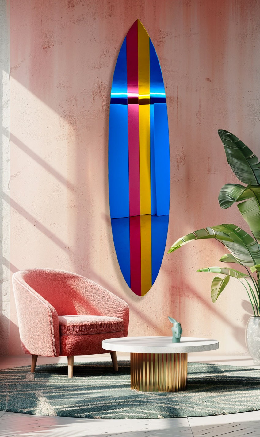 The uniQstiQ Retro Surfboard Wall Art, a mirrored acrylic pop art piece, hangs above a pink chair and round table with gold base on a pink wall.